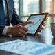 Professionnel en tenue d'affaires analysant un graphique financier sur une tablette